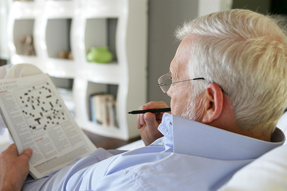 Man doing crossword puzzle at home